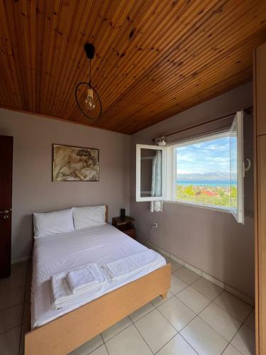a bedroom with a bed and a window at Xenia's Seaview House in Paralía Avlídhos