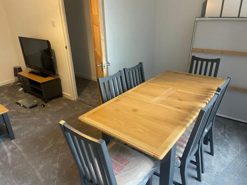 a wooden table and chairs in a room with a tv at April Disc - Long Stay - Contractors in Bristol