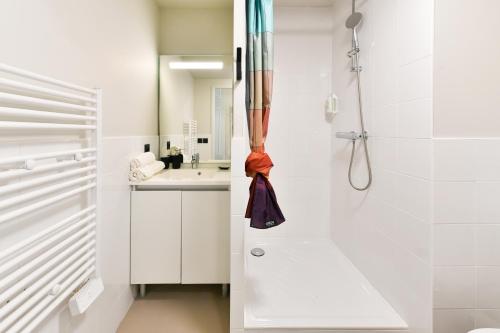 a white bathroom with a shower and a sink at Student Factory Toulouse Zénith in Toulouse
