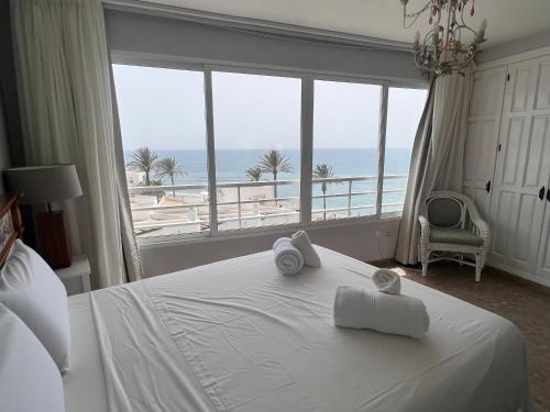 Un dormitorio con una cama con vista al mar. en Primera linea de playa, en Cabopino