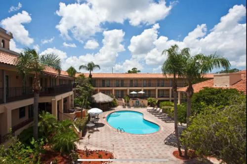 an exterior view of a resort with a swimming pool at Red Roof Inn PLUS & Suites Tampa in Tampa