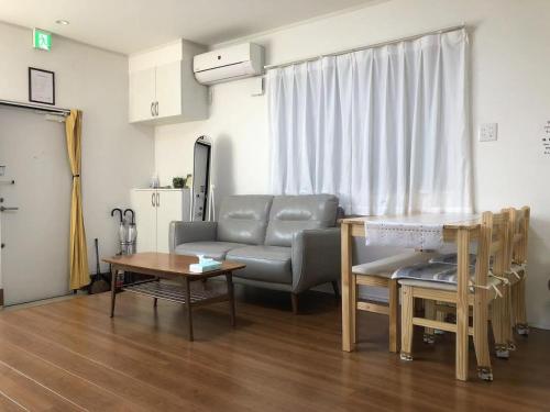 uma sala de estar com um sofá e uma mesa em Maisonette Hanazono - Vacation STAY 97278v em Chiba