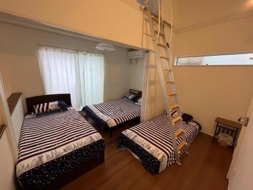 千葉市にあるMaisonette Hanazono - Vacation STAY 97278vの二段ベッド2組とはしごが備わる客室です。
