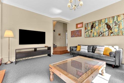a living room with a couch and a tv at Twenty 2 Abbey in Leura