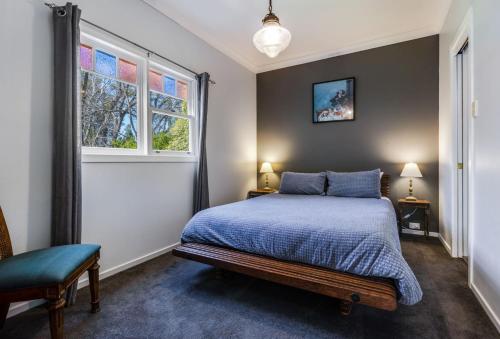 a bedroom with a bed and two windows at Twenty 2 Abbey in Leura