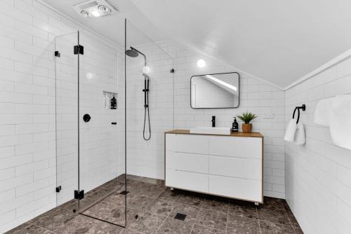 a white bathroom with a sink and a shower at Twenty 2 Abbey in Leura