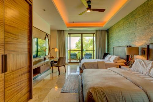 Mesas de PicachosにあるThe Estates Four Bedroom Loft E1- Nuevo Vallartaのベッド2台とテレビが備わるホテルルームです。