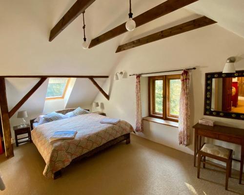 een slaapkamer met een bed, een bureau en ramen bij Bohemian forest paradise 