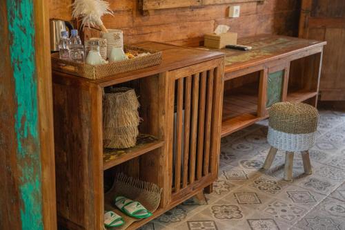 um balcão de madeira num quarto com uma mesa em Jukung Cottage em Nusa Penida
