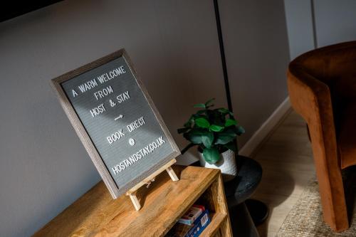 a sign on a wooden table next to a plant at Host & Stay - Ropewalks Quarters in Liverpool