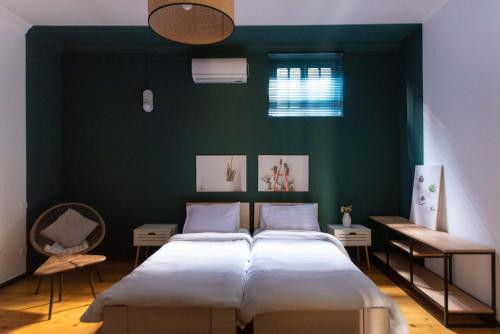 een slaapkamer met 2 bedden en een groene muur bij Veranda House on Samreklo 25 in Tbilisi City