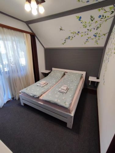 a small bedroom with a bed with flowers on the wall at Садиба АнноМарі - відпочинок в Карпатах котедж Яремче in Yaremche