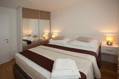a bedroom with two beds and a mirror at Apartments Diamond in Podstrana