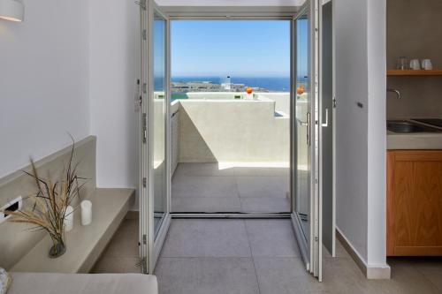 a room with a staircase and a view of the ocean at Adorno Oia in Oia