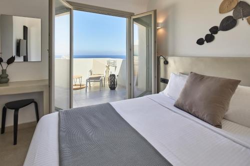 a bedroom with a bed and a view of the ocean at Adorno Oia in Oia