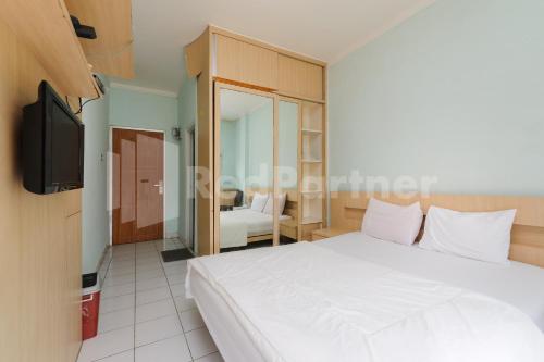 Ένα ή περισσότερα κρεβάτια σε δωμάτιο στο Tanres House Syariah Cilandak Mitra RedDoorz