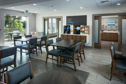 a dining room with tables and chairs in a restaurant at Holiday Inn Express Corvallis-On the River, an IHG Hotel in Corvallis