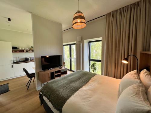 1 dormitorio con 1 cama y TV de pantalla plana en Lovely apartment by the sea., en Ķesterciems