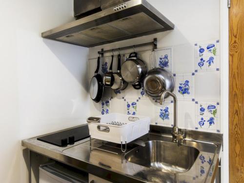 - une cuisine avec évier, casseroles et poêles dans l'établissement Pass the Keys Cozy studio flat in trendy Brixton, à Londres
