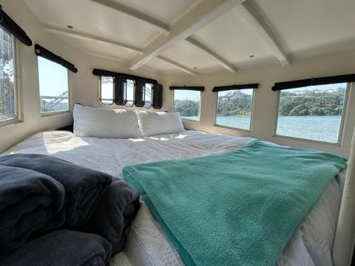 ein Schlafzimmer mit einem großen Bett in der Mitte in der Unterkunft Baby Blue Houseboat in Port Edward