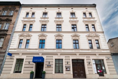 a large white building with many windows at Golden Tulip Krakow City Center in Kraków