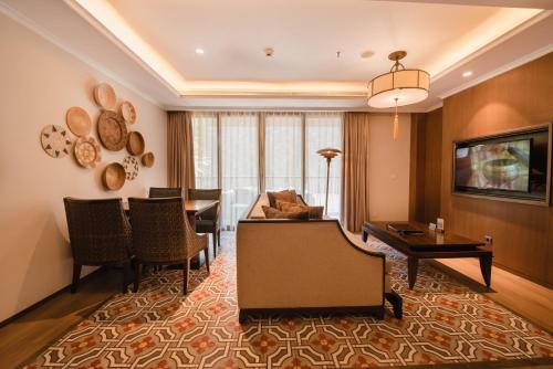 a living room with a table and a dining room at Ramayana Suites and Resort in Kuta