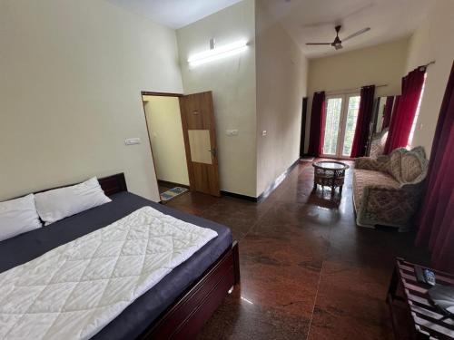 a bedroom with a bed and a living room at Forest View Resort in Yercaud