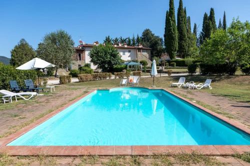 ein Pool mit Stühlen und ein Haus im Hintergrund in der Unterkunft Fienile panoramico nel Chianti in Greve in Chianti