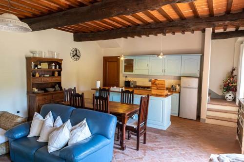 a living room with a table and a blue couch at Fienile panoramico nel Chianti in Greve in Chianti