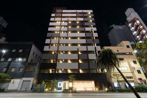 a tall building at night with lights on at stayme THE HOTEL Asakusa Riverside in Tokyo