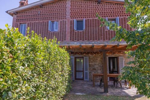 a brick house with a table in front of it at Fienile panoramico nel Chianti in Greve in Chianti