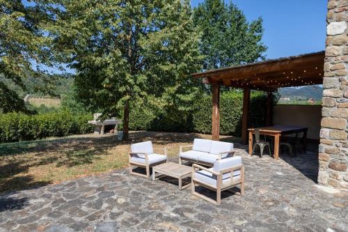 a group of chairs and a table and a pavilion at Fienile panoramico nel Chianti in Greve in Chianti