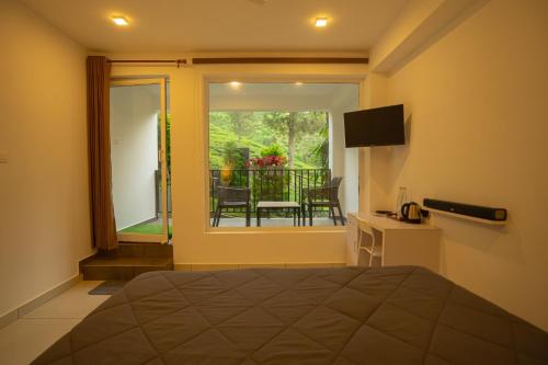 Un dormitorio con una cama y vista a un balcón. en Teaberg Estate Haus, en Munnar