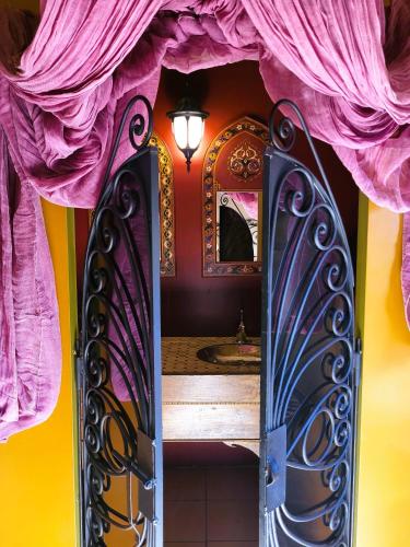 La salle de bains est pourvue d'un miroir et d'un rideau rose. dans l'établissement Les Causeries du Monde, à Chamboulive