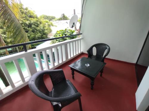a balcony with two chairs and a table at Hotel Mount Lanka in Watumulla