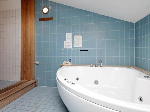 a bath tub in a bathroom with blue tiles at 8 person holiday home in Harbo re in Harboør