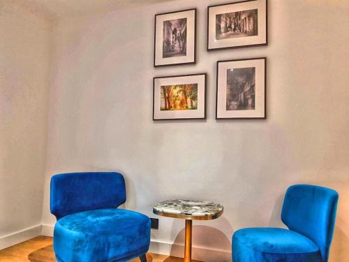 a room with two blue chairs and a table at suite st lo 2 in Rouen