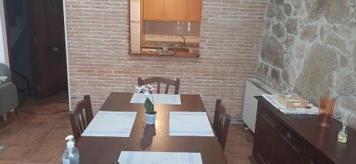 a wooden table with chairs and a brick wall at Apartamento Tui Centro in Tui