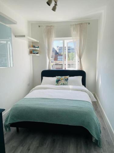 Un dormitorio con una cama grande con ventana. en Stunning huge openplan 2Bed flat, en Woking
