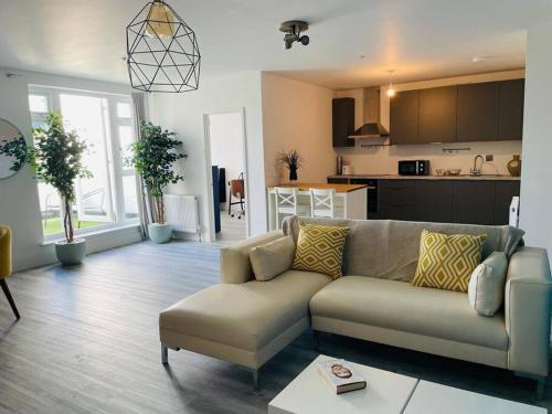 a living room with a couch and a kitchen at Stunning huge openplan 2Bed flat in Woking
