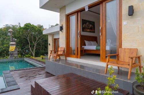 a villa with a bedroom and a swimming pool at Sari Sky Bali in Kubupenlokan