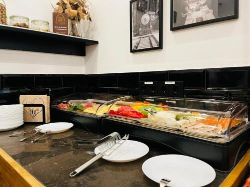a buffet line with plates and food in a restaurant at Designhotel Central Fulda in Fulda