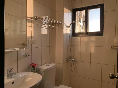 baño con lavabo y aseo y ventana en White Cat B&B, en Jinning