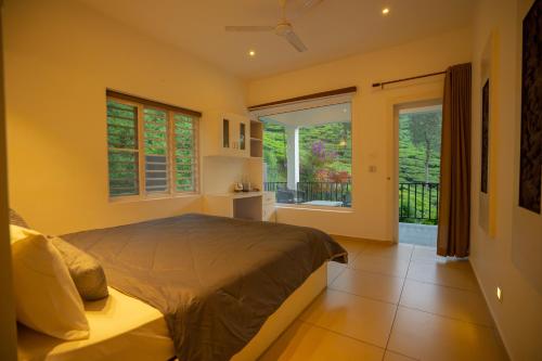 een slaapkamer met een bed en een groot raam bij Teaberg Estate Haus in Munnar