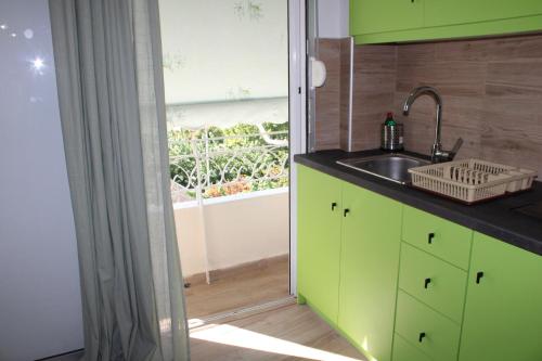 uma cozinha com armários verdes e um lavatório em Athens City Themis 16 em Atenas