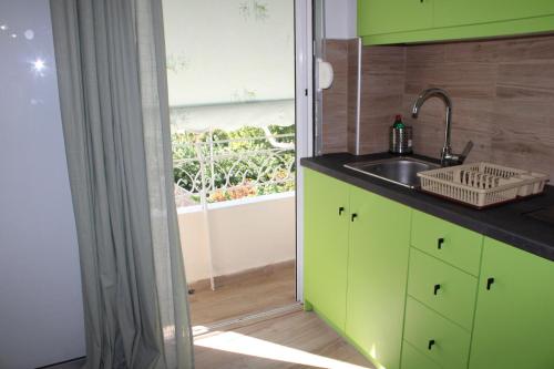 een keuken met groene kasten en een spoelbak bij Athens City Themis 16 in Athene