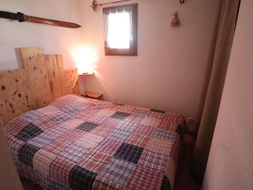 une chambre avec un lit avec une couverture à carreaux dans l'établissement Appartement au pied des pistes, terrasse, calme, 4 pers, Arêches-Beaufort - FR-1-342-287, à Beaufort