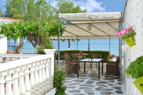 patio ze stołem i krzesłami oraz oceanem w obiekcie Blu w mieście Glifa