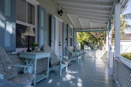 een veranda met stoelen en een tafel op een huis bij Watercolor home in Harbour Island