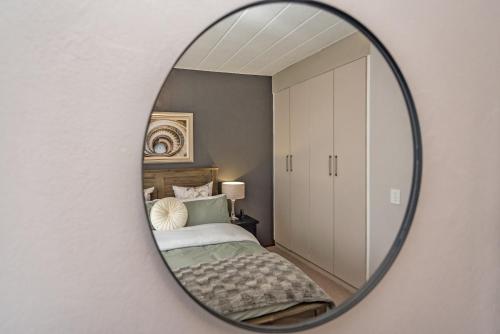 a mirror reflecting a bedroom with a bed at CLASSIC A&W in Sandton